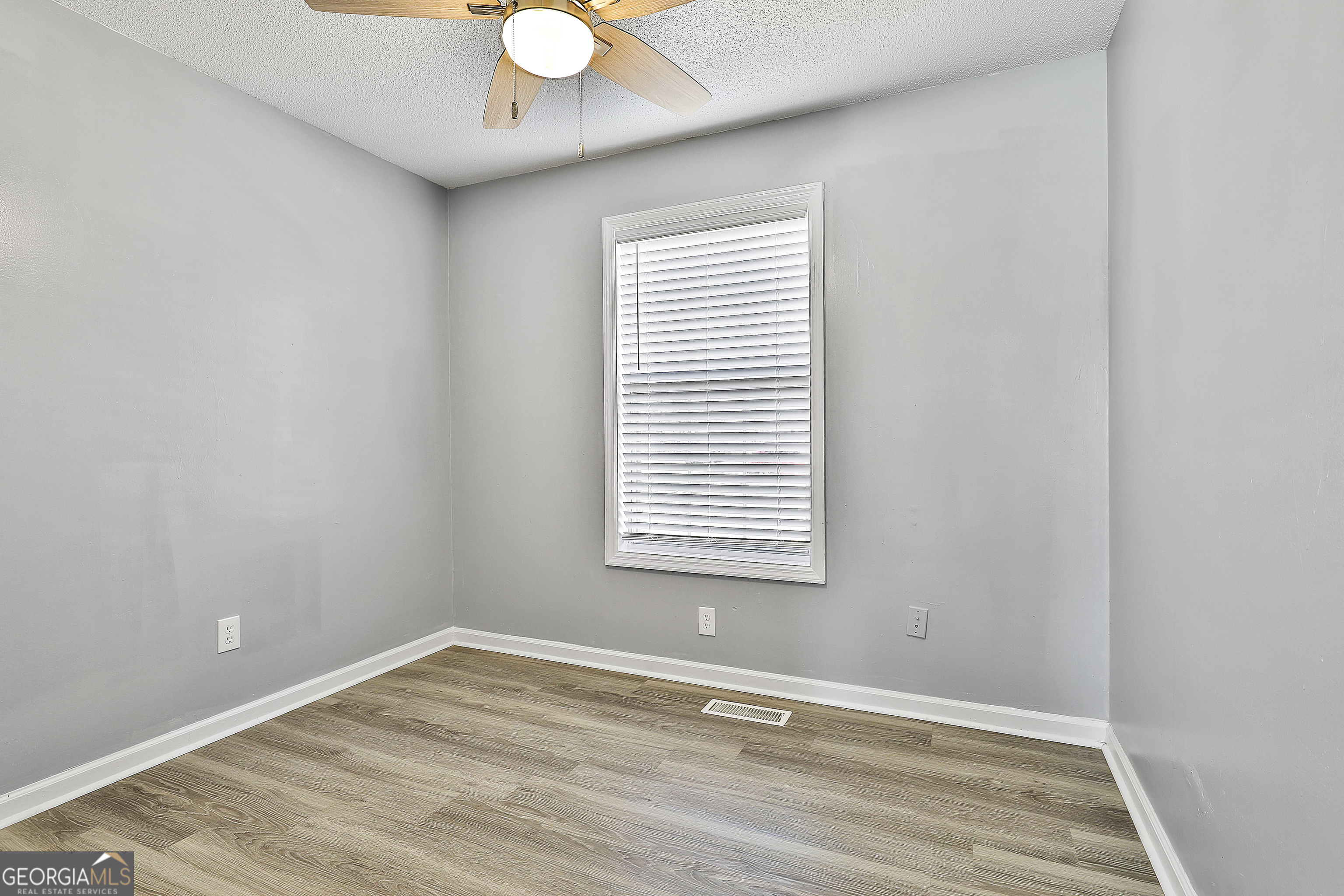 1209 North Hampton Drive Hampton, GA 30228 - Photo 26 of 39 a view of an empty room with wooden floor and a window