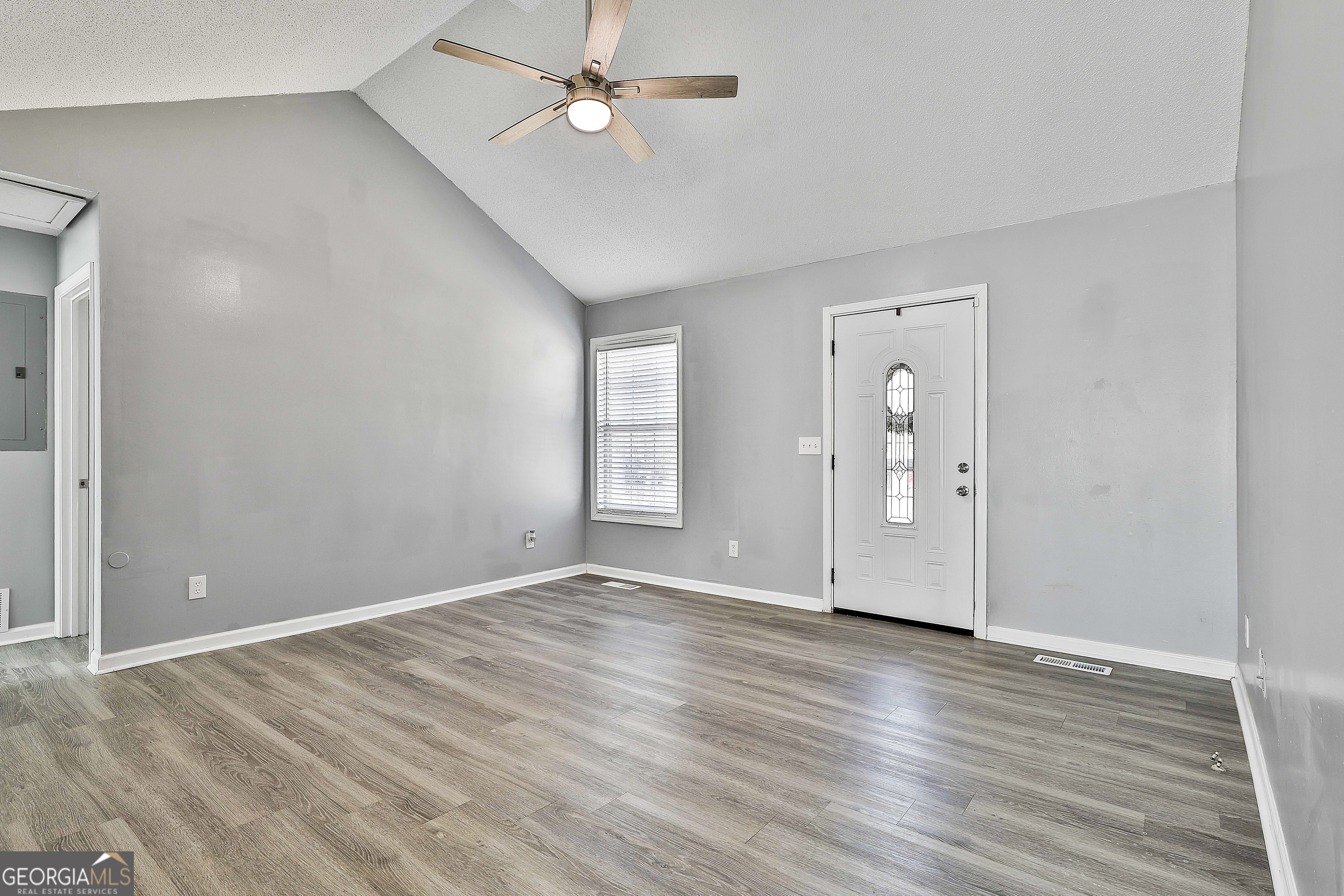 1209 North Hampton Drive Hampton, GA 30228 - Photo 9 of 39 an empty room with wooden floor and windows