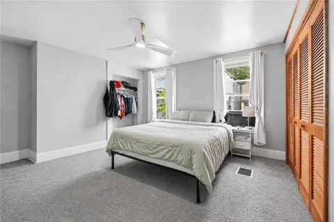 a spacious bedroom with a bed closet and a window
