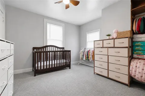 a view of a bedroom with baby crib and furniture