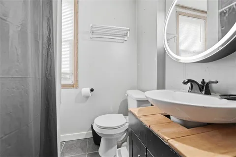 a bathroom with a sink a toilet and mirror