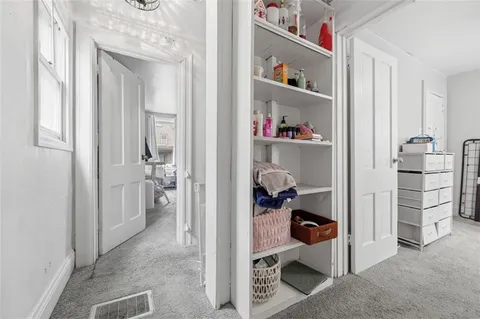 a room with a walk in closet and a chair
