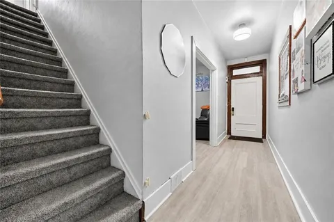 a view of a livingroom with wooden floor and stairs