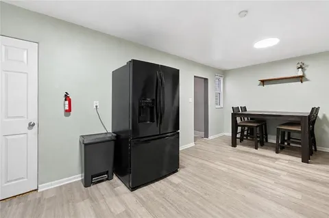 a kitchen with a refrigerator and a wooden floor