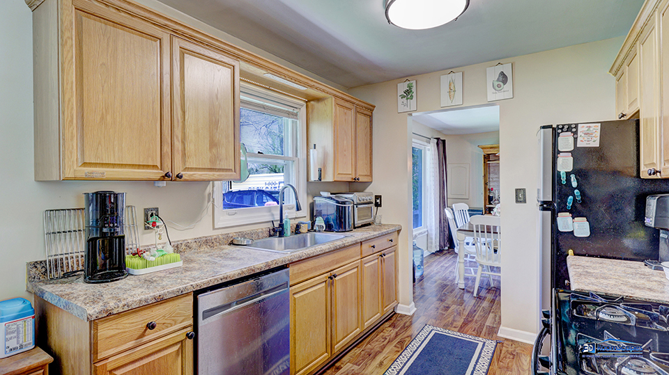 319 Croyden Street Spring Grove, IL 60081 - Photo 9 of 42 a kitchen with stainless steel appliances granite countertop a sink dishwasher cabinets and couches with wooden floor