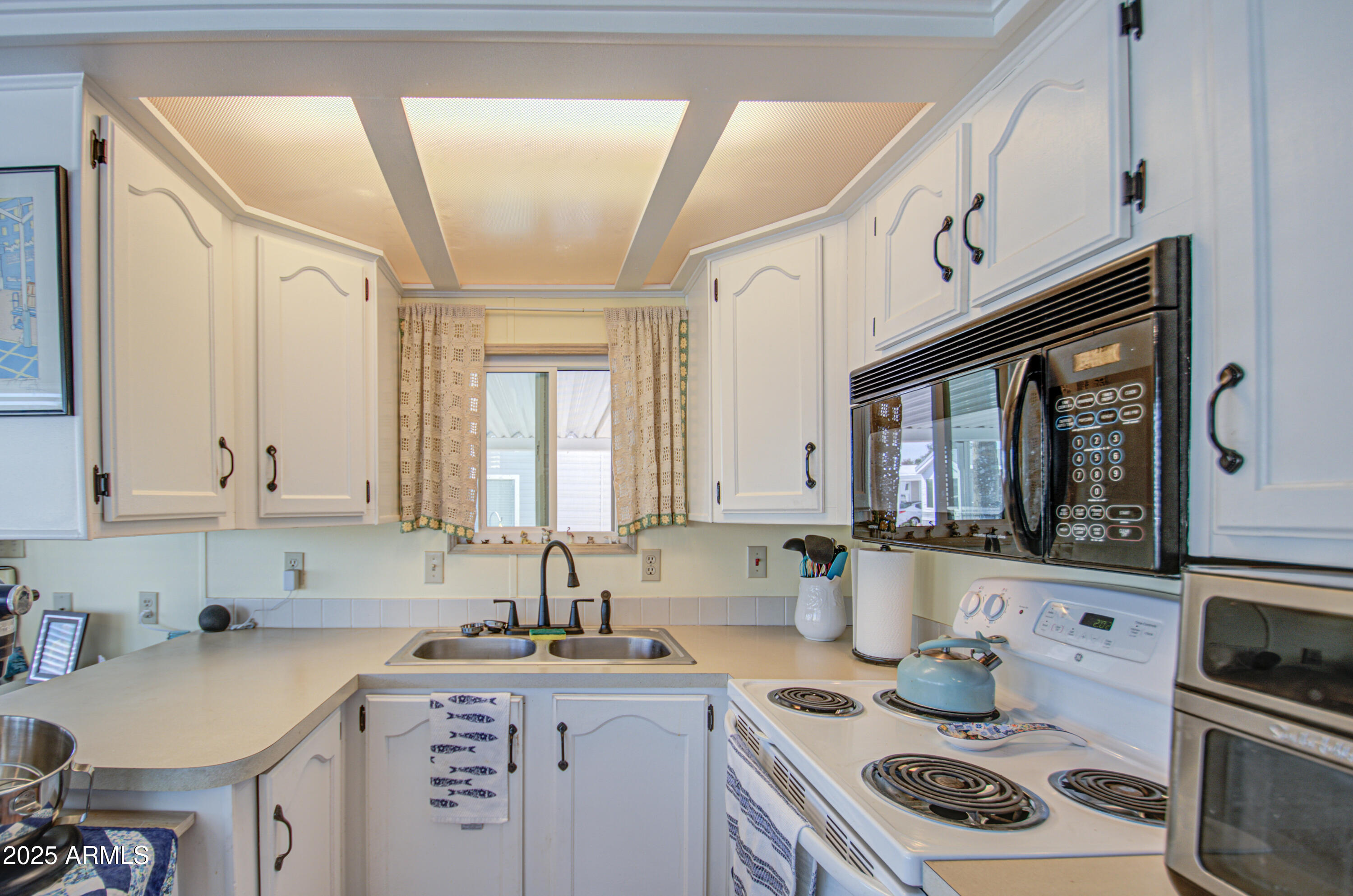 7750 East Broadway Road, Unit 475 Mesa, AZ 85208 - Photo 6 of 34 a kitchen with granite countertop a sink stove and cabinets
