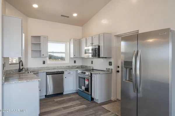 a kitchen with stainless steel appliances granite countertop a refrigerator and a sink