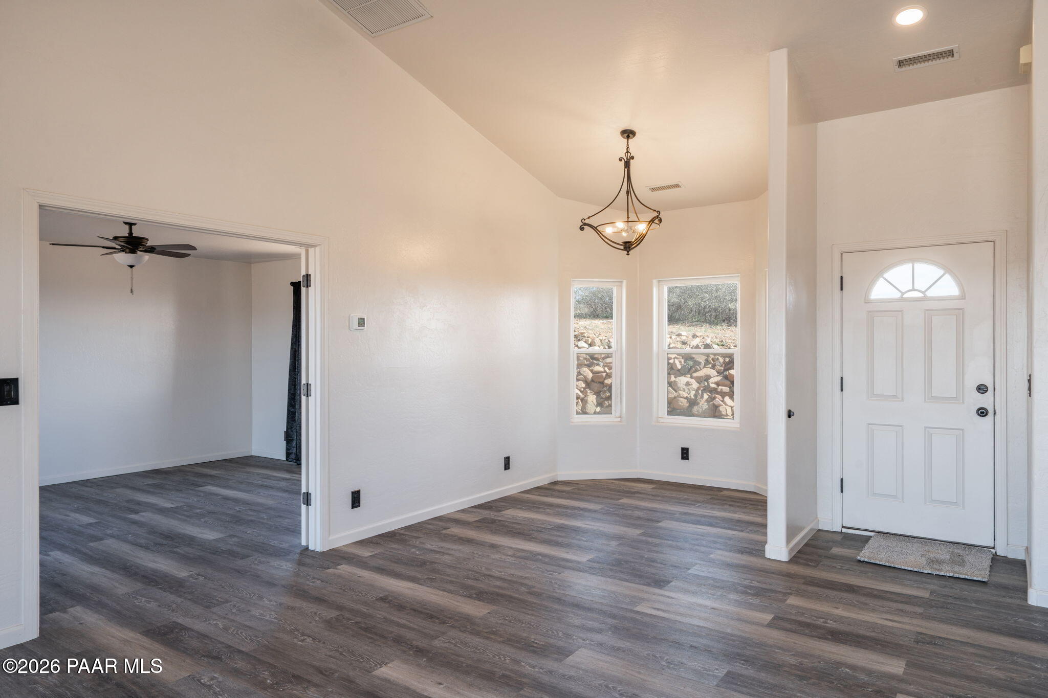 16751 Leprechaun Road Dewey, AZ 86327 - Photo 10 of 46 an empty room with wooden floor chandelier and windows