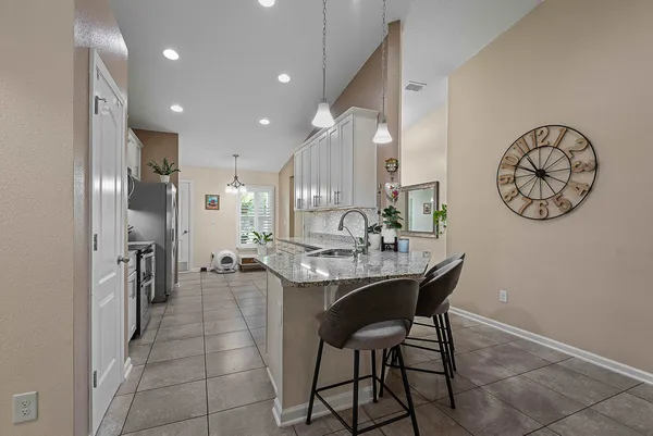 a kitchen with kitchen island granite countertop a sink stove and refrigerator
