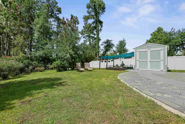 a front view of a house with a garden and lake view