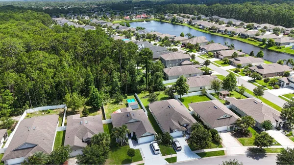 an aerial view of residential house with outdoor space and trees all around