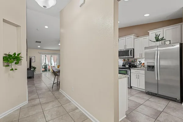 a living room with furniture a wooden floor and kitchen view