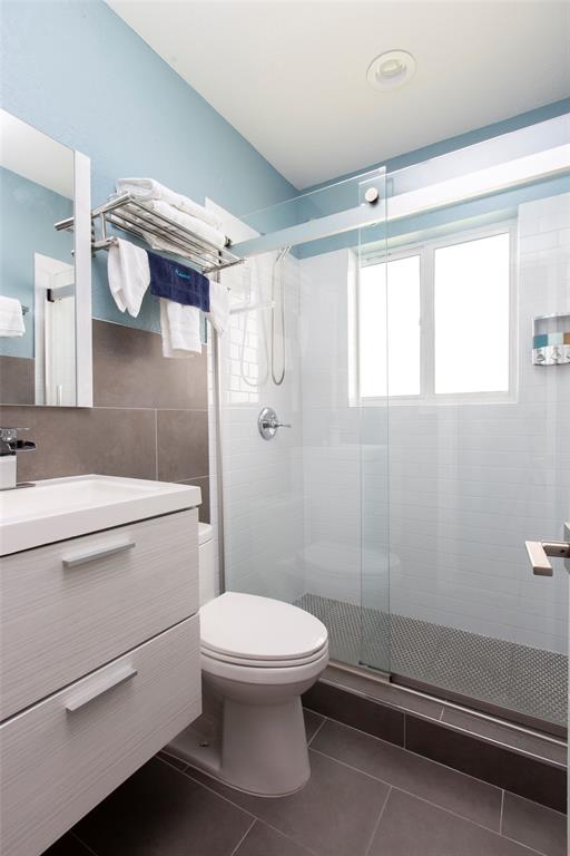 3217 Northeast 9th Street, Unit 5 Pompano Beach, FL 33062 - Photo 1 of 12 a bathroom with a toilet a sink and shower