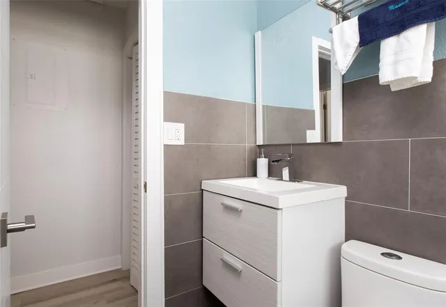 a bathroom with a sink a toilet and a mirror