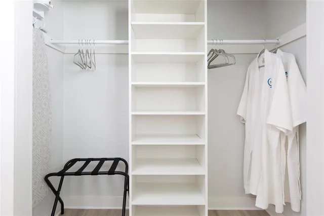 a view of walk in closet with empty racks