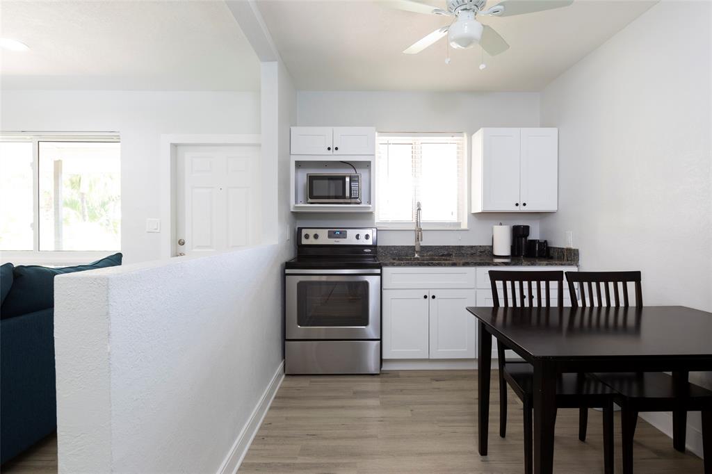 3217 Northeast 9th Street, Unit 5 Pompano Beach, FL 33062 - Photo 6 of 12 a kitchen with a stove a sink and a microwave