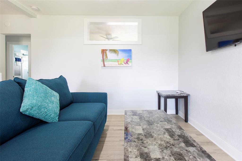 3217 Northeast 9th Street, Unit 5 Pompano Beach, FL 33062 - Photo 9 of 12 a living room with furniture and a flat screen tv