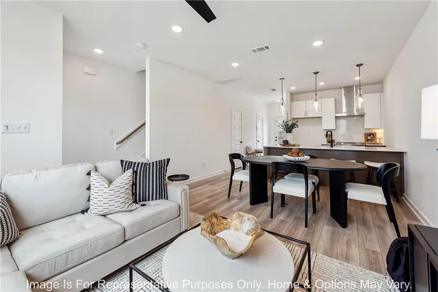 a living room with furniture and a dining table with kitchen view