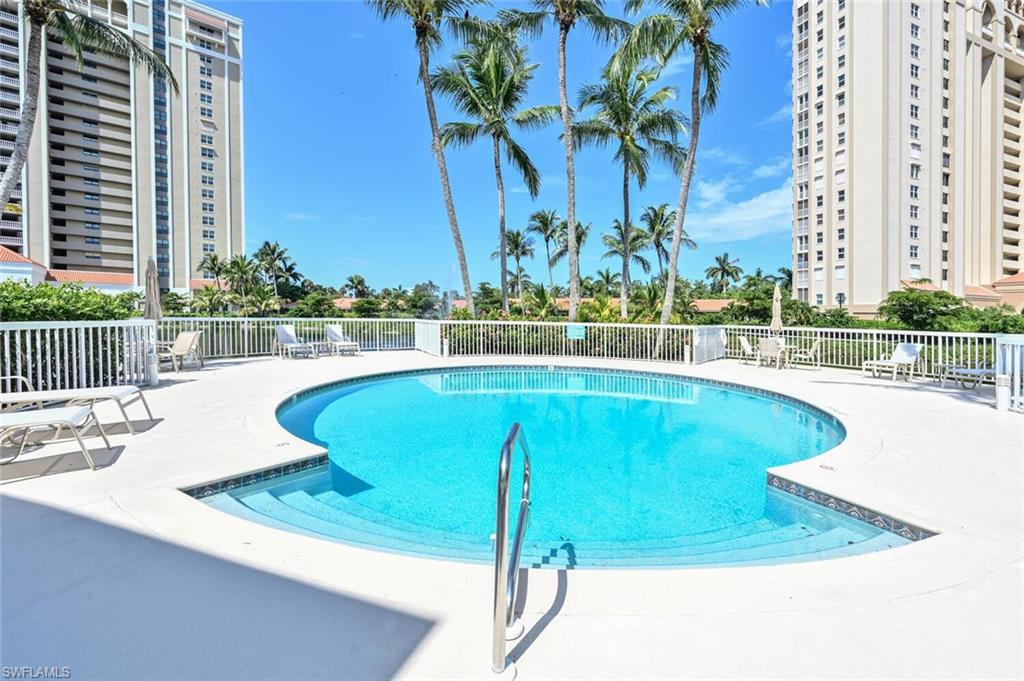 6549 Marissa Loop, Unit 26 Naples, FL 34108 - Photo 30 of 39 a view of a swimming pool with a lawn chairs