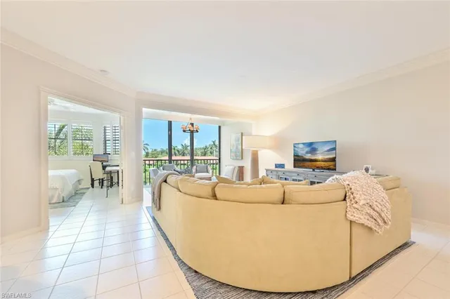 a living room with furniture a large window and a flat screen tv
