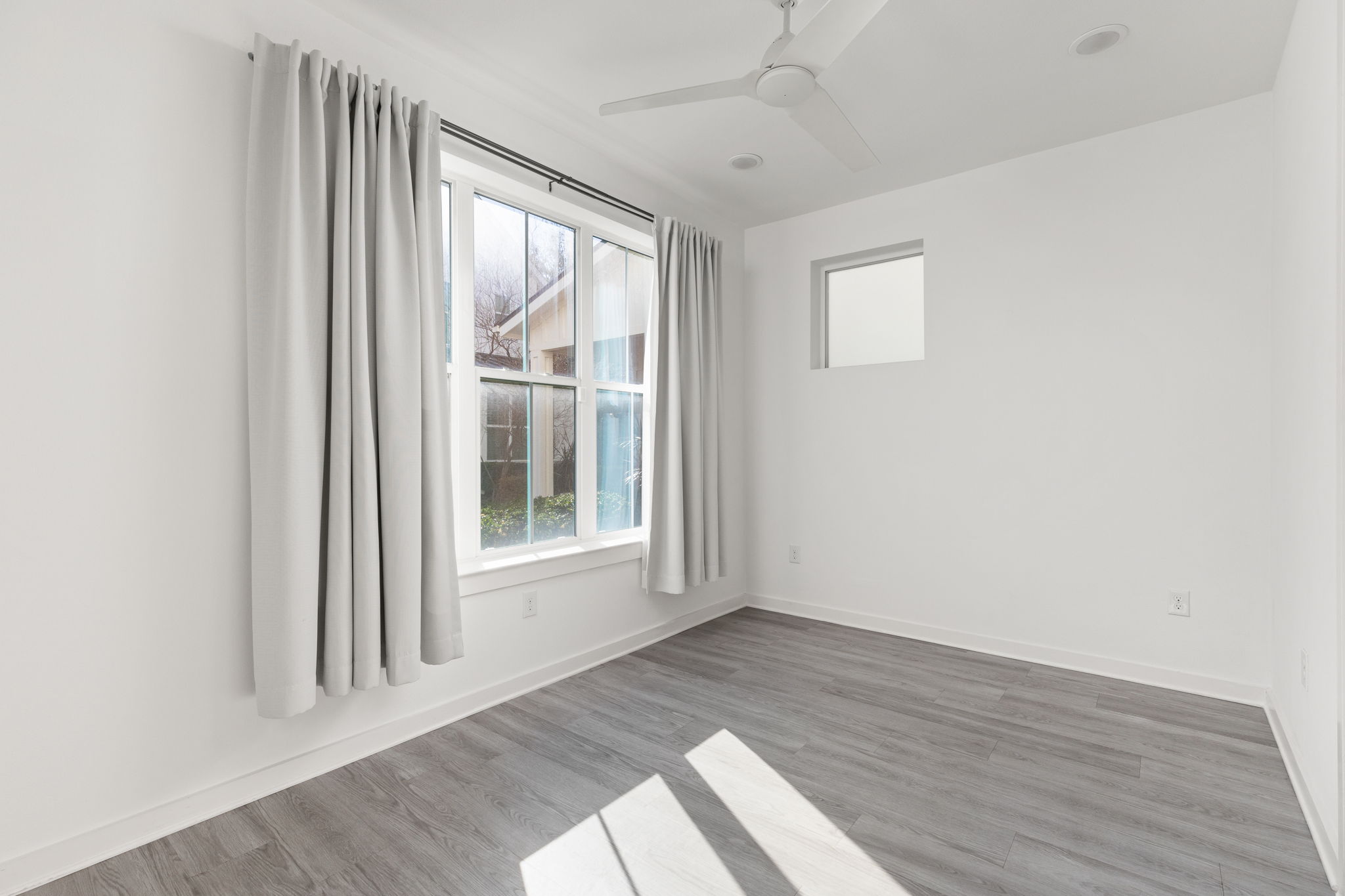 2624 Metcalfe Road, Unit 17 Austin, TX 78741 - Photo 5 of 35 an empty room with wooden floor and windows