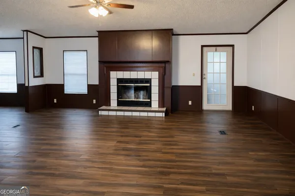 a view of a livingroom with a fireplace wooden floor and a window