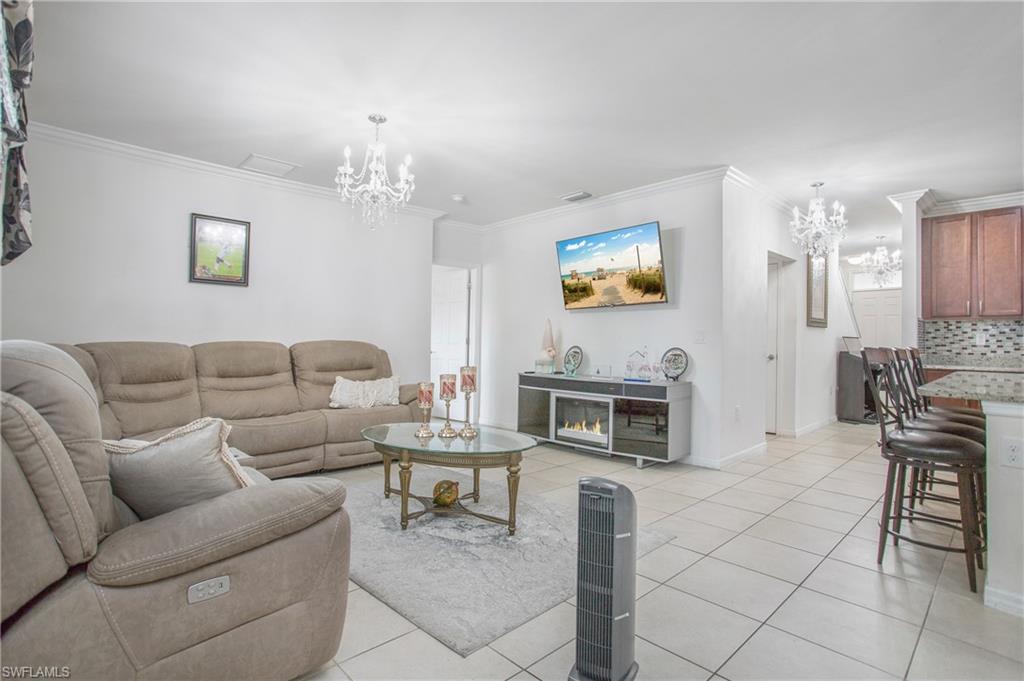 673 Hadley Street East Naples, FL 34104 - Photo 13 of 31 a living room with furniture a fireplace and a flat screen tv