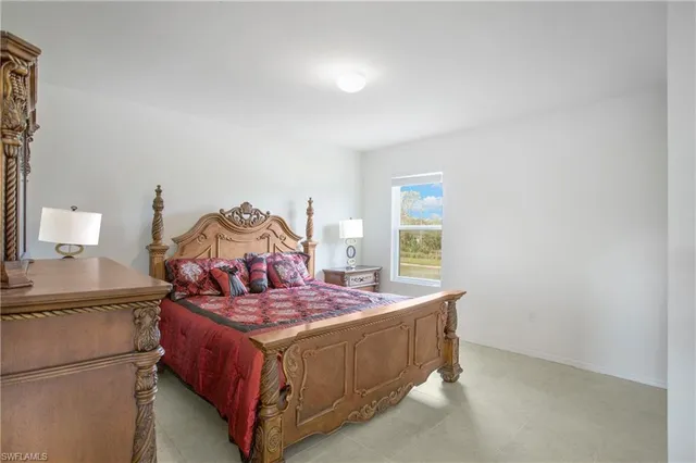 a bedroom with a bed and a lamp on the dresser