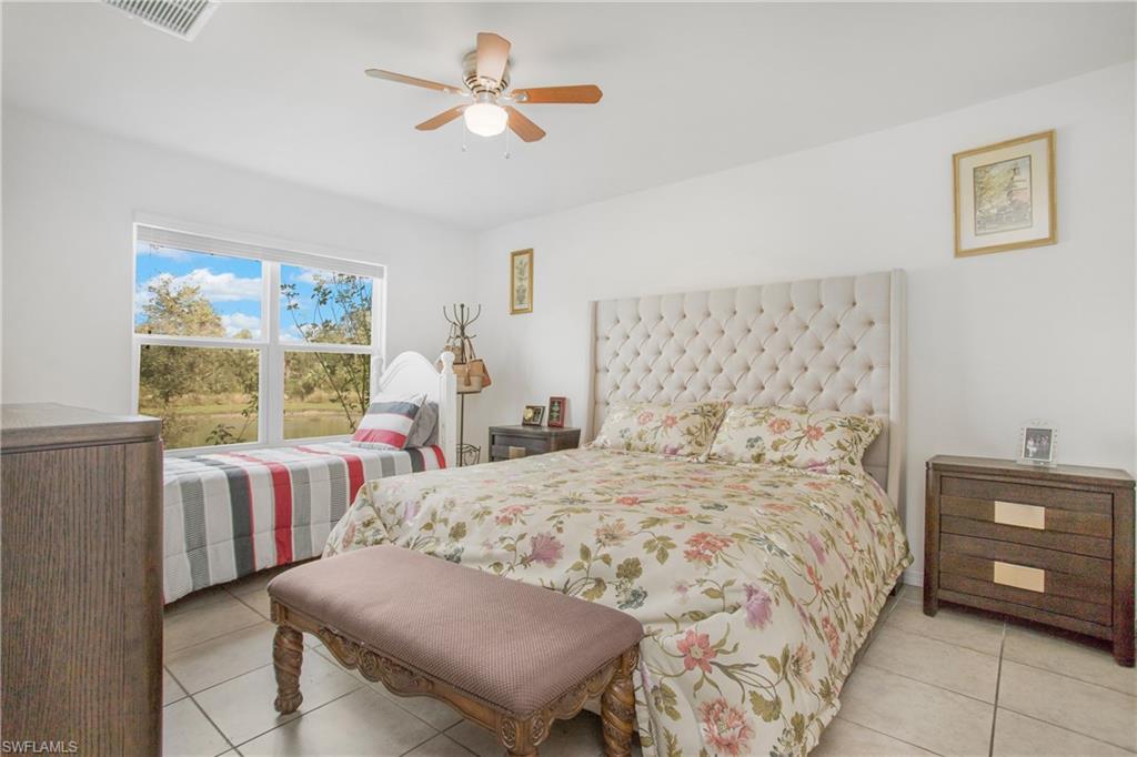 673 Hadley Street East Naples, FL 34104 - Photo 25 of 31 a bedroom with a bed a dresser and next to a window