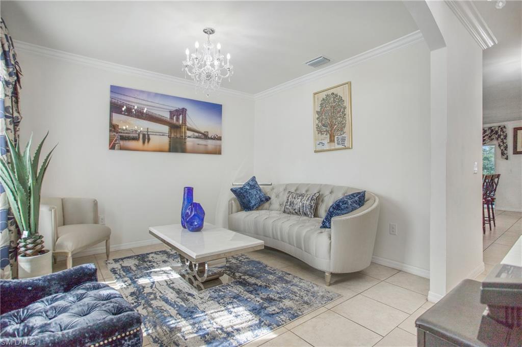 673 Hadley Street East Naples, FL 34104 - Photo 6 of 31 a living room with furniture and a chandelier