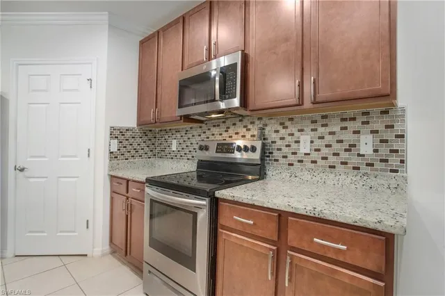 a kitchen with granite countertop cabinets stainless steel appliances and a counter space