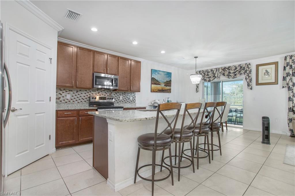 673 Hadley Street East Naples, FL 34104 - Photo 10 of 31 a kitchen with stainless steel appliances granite countertop a stove a sink a microwave and a refrigerator