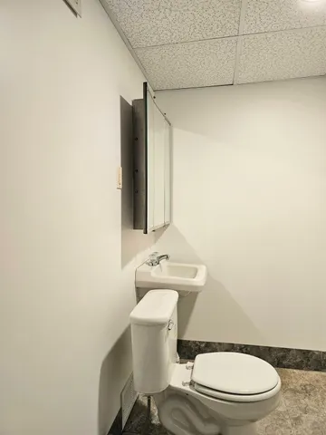 a white toilet sitting next to a bathroom sink