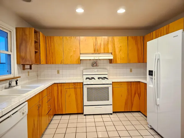 a kitchen with stainless steel appliances a stove a sink and a refrigerator