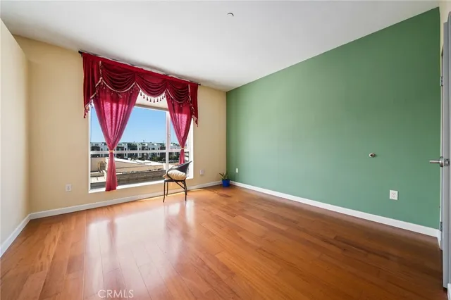 a walk in closet with wooden floor