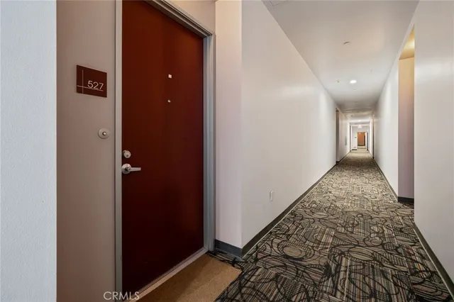 a large kitchen with stainless steel appliances a large counter top a refrigerator and a view of living room