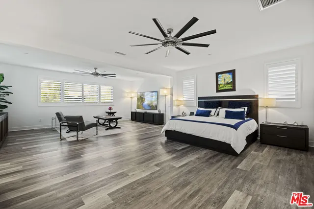 a living room with furniture a flat screen tv and a ceiling fan