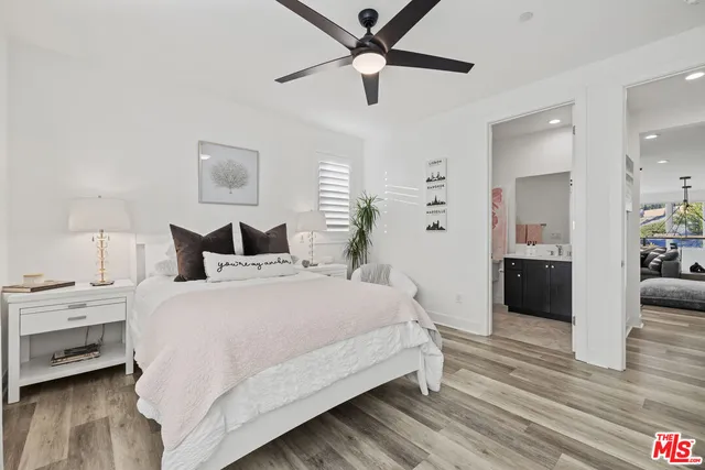 an empty room with wooden floor and a ceiling fan
