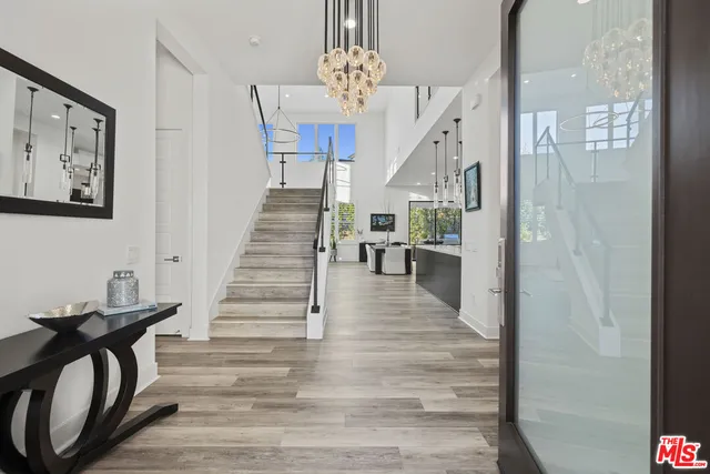 a large white kitchen with a sink and refrigerator
