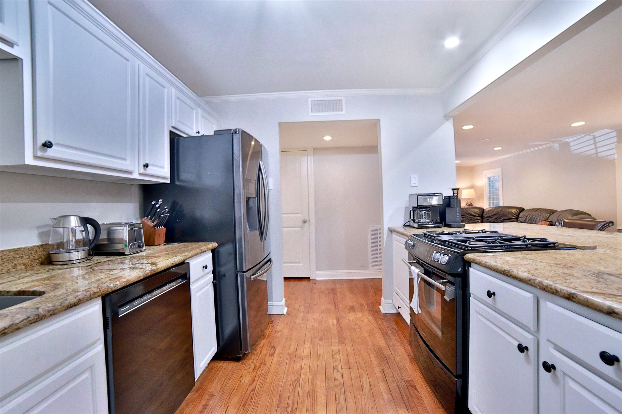 2625 Peckham Street Houston, TX 77098 - Photo 8 of 27 a kitchen with stainless steel appliances granite countertop a stove top oven a refrigerator a sink and dishwasher with wooden floor