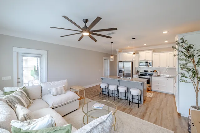 a living room with furniture and a view of kitchen