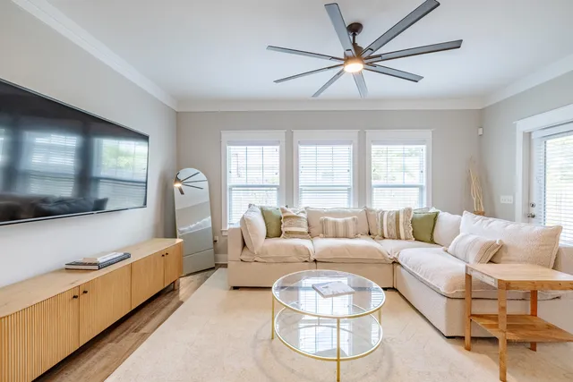 a living room with furniture and a large window with wooden floor
