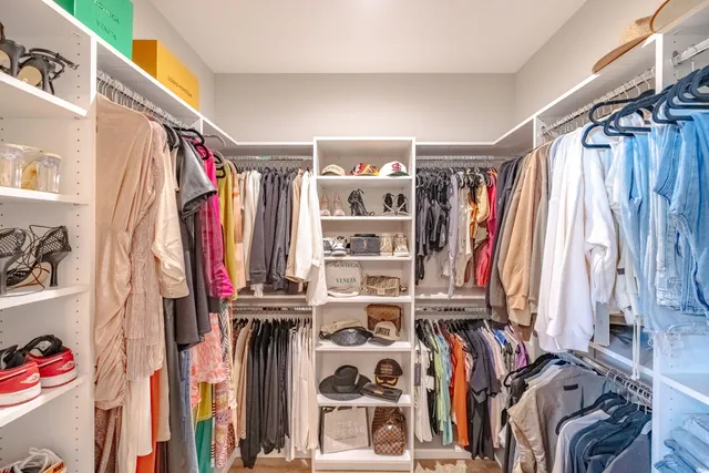 a view of walk in closet with clothes