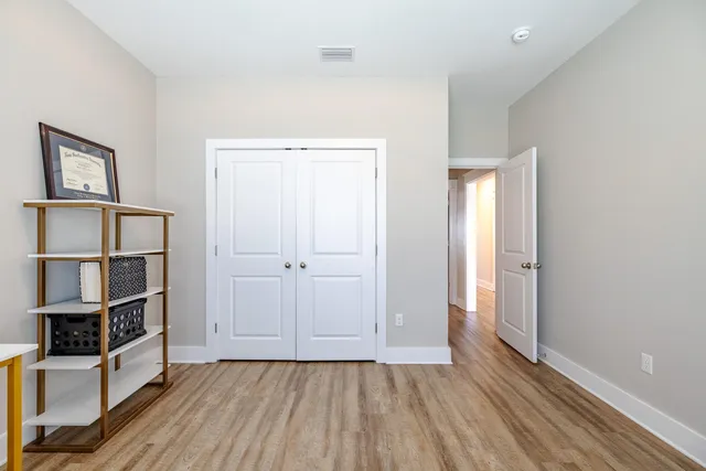 an empty room with wooden floor and closet