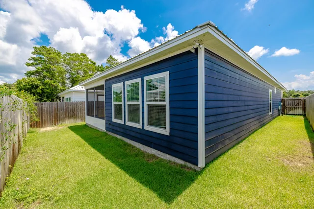a view of a backyard with wooden fence and floor