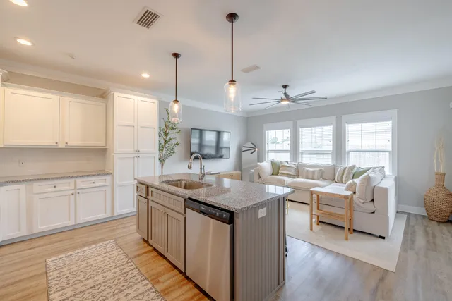 a kitchen with granite countertop a sink stove and cabinets