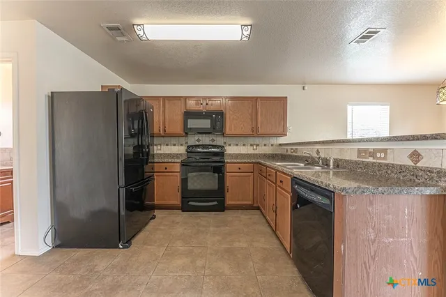 an empty room with windows and ceiling fan