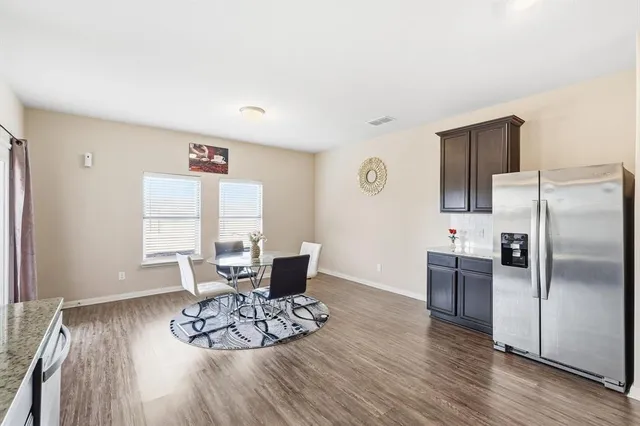 a dining room with wooden floor and a chandelier