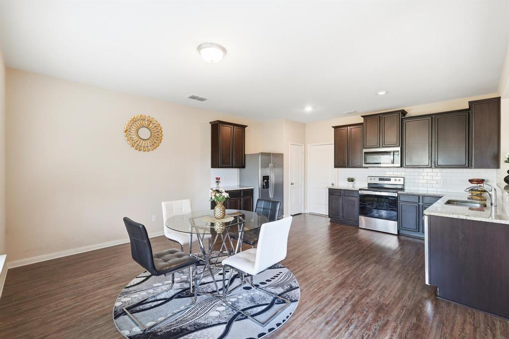 227 Curt Street Anna, TX 75409 - Photo 15 of 40 a living room with furniture a fireplace and a flat screen tv