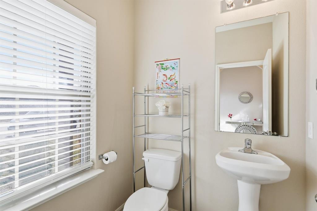 227 Curt Street Anna, TX 75409 - Photo 16 of 40 a bathroom with a toilet sink and mirror